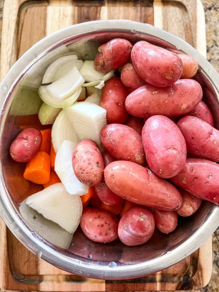 baby potatoes, onions, and carrots in a bowl to be used for stew