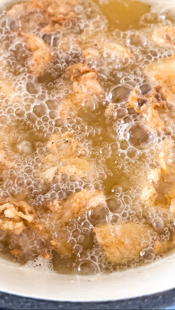 close up view of chicken frying in a skillet