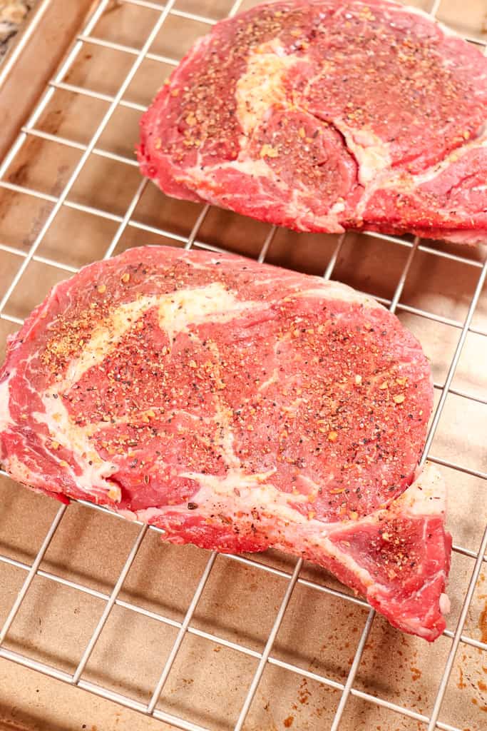 ribeye steak on a rack that is seasoned and ready to reverse sear