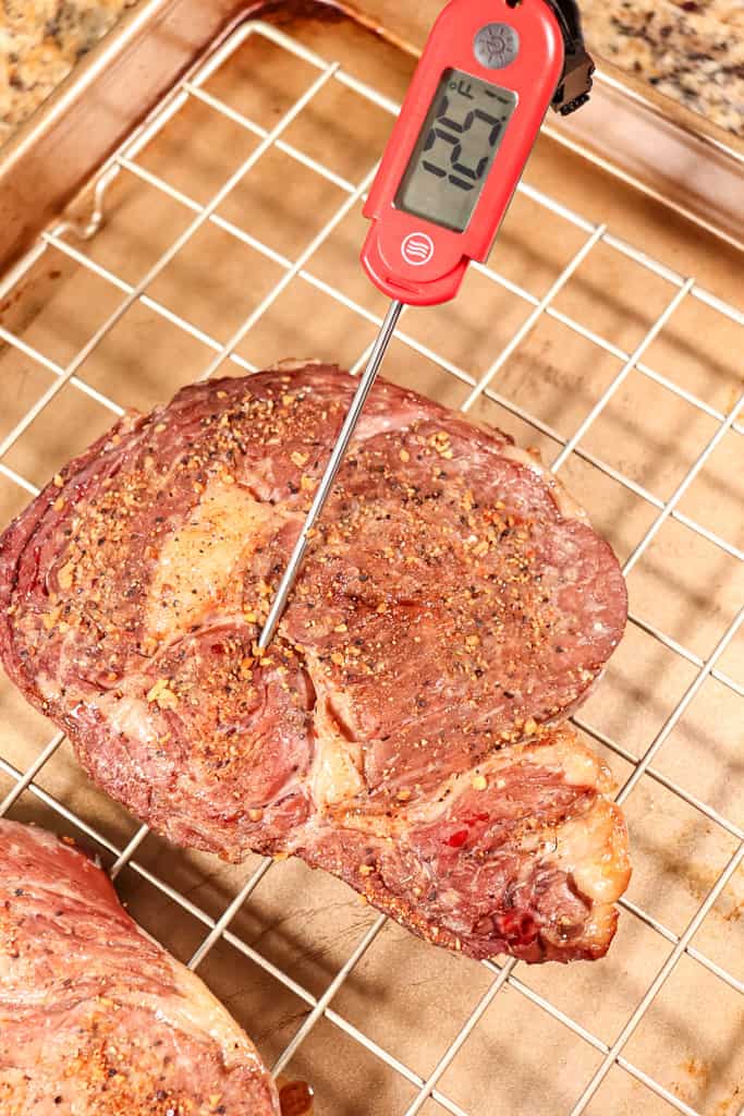a temperature meat thermometer that reading a reverse seared ribeye that is at 125 degrees fahrenheit