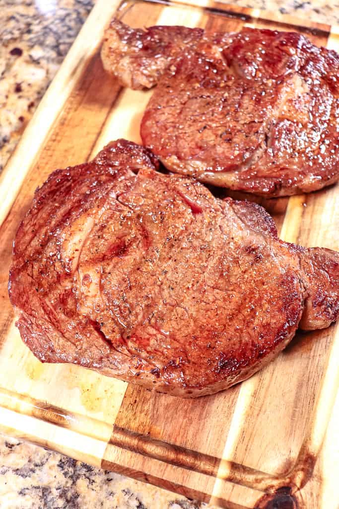 reverse seared ribeye on a cutting board to rest