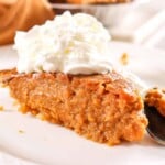 a slice of sweet potato pie with whipped cream on top