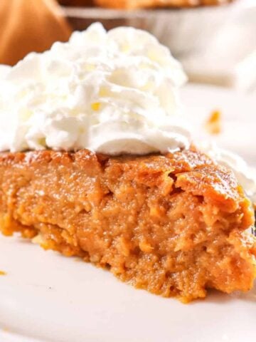 a slice of sweet potato pie with whipped cream on top