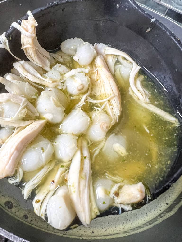 pozole verde sauce in a large pot with chicken and hominy