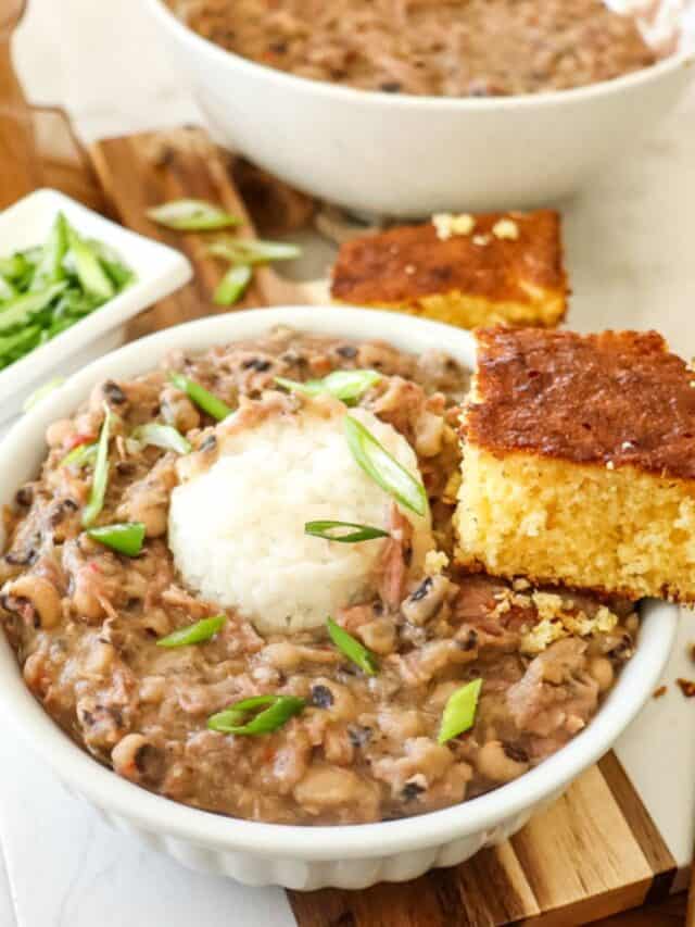 bowl of black eyed peas with a side of cornbread and rice on top