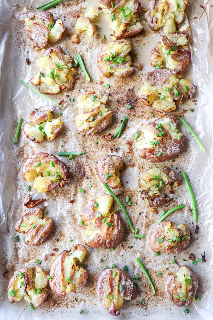 overhead view of cooked crispy smashed potatoes on a baking sheet
