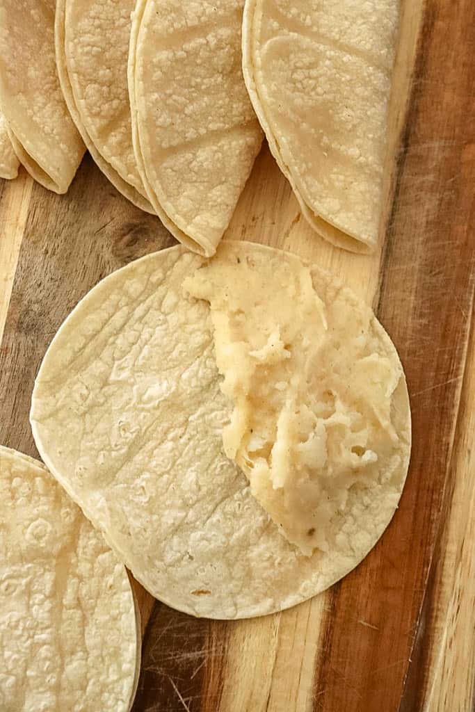 mashed potatoes smeared on half of a corn tortilla
