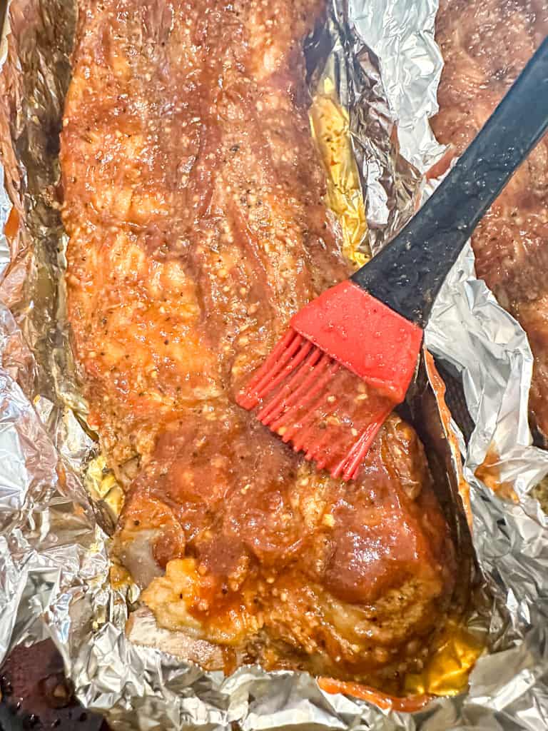 meat being brushed with sauce