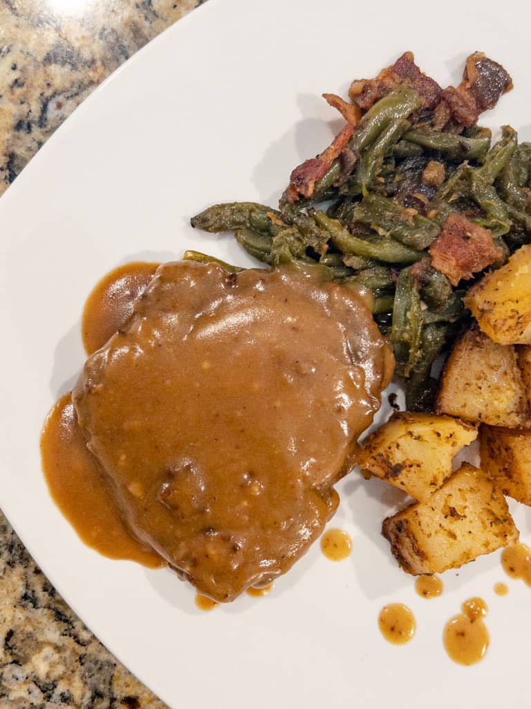 overhead view of plated cube steaks with potatoes and string beans