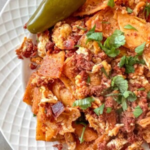 close up view of plated migas with chorizo with a side of jalapeno