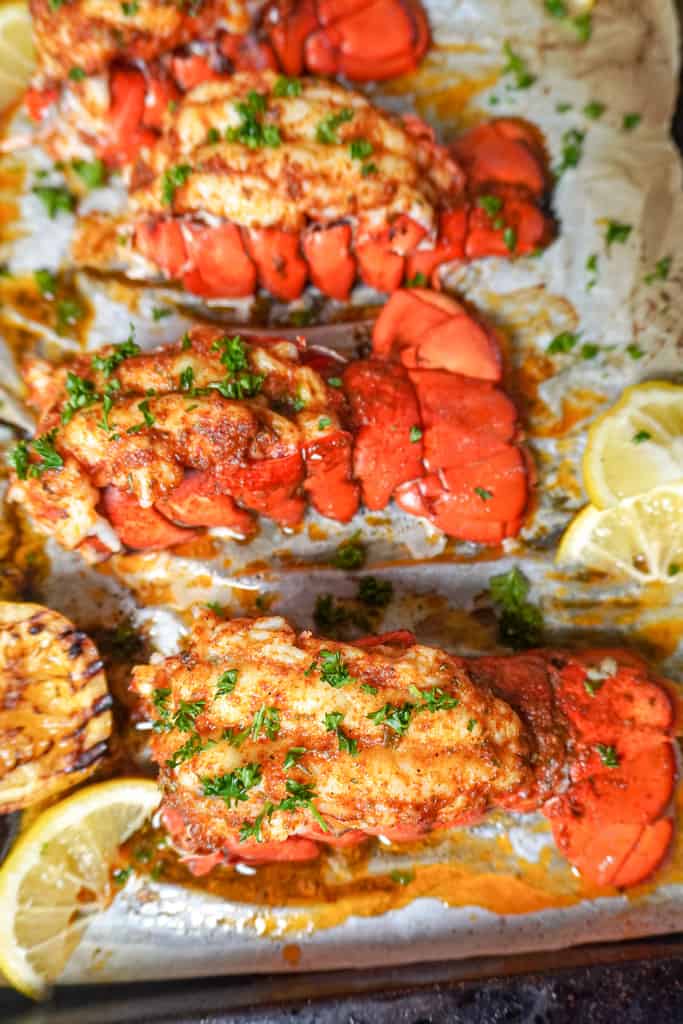 overhead view of baked lobster tails on a sheet pan