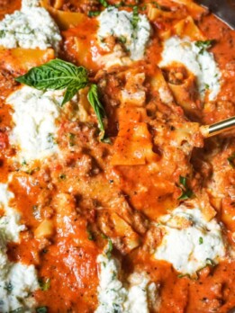 a spoonful of lasagna over a pot of skillet lasagna