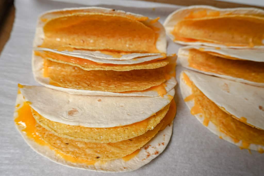 cheesy gordita crunch taco shells on parchment paper