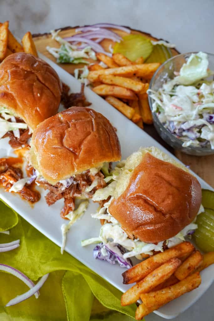 plated pulled pork sliders with fries and coleslaw in the background