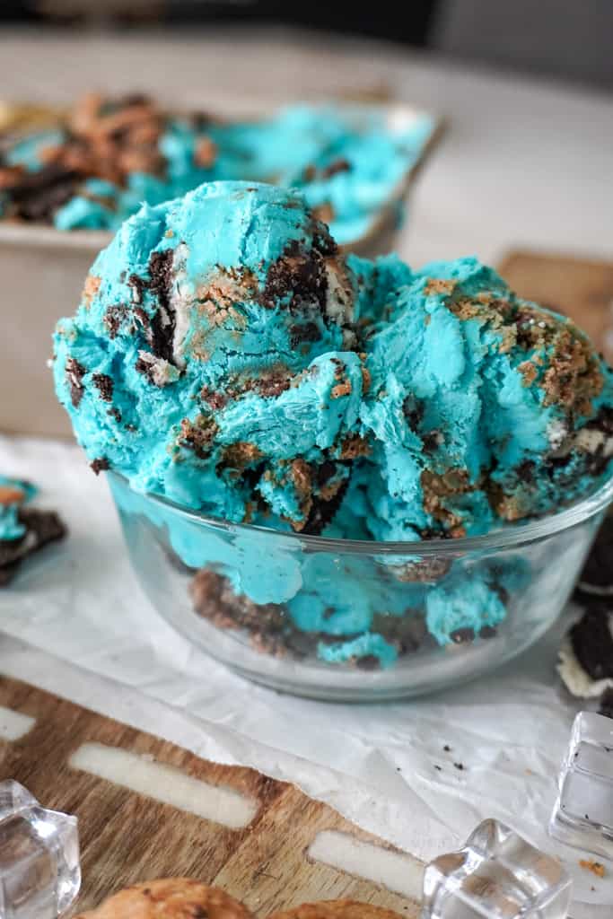 ice cream in a clear bowl with small pieces of cookies around it