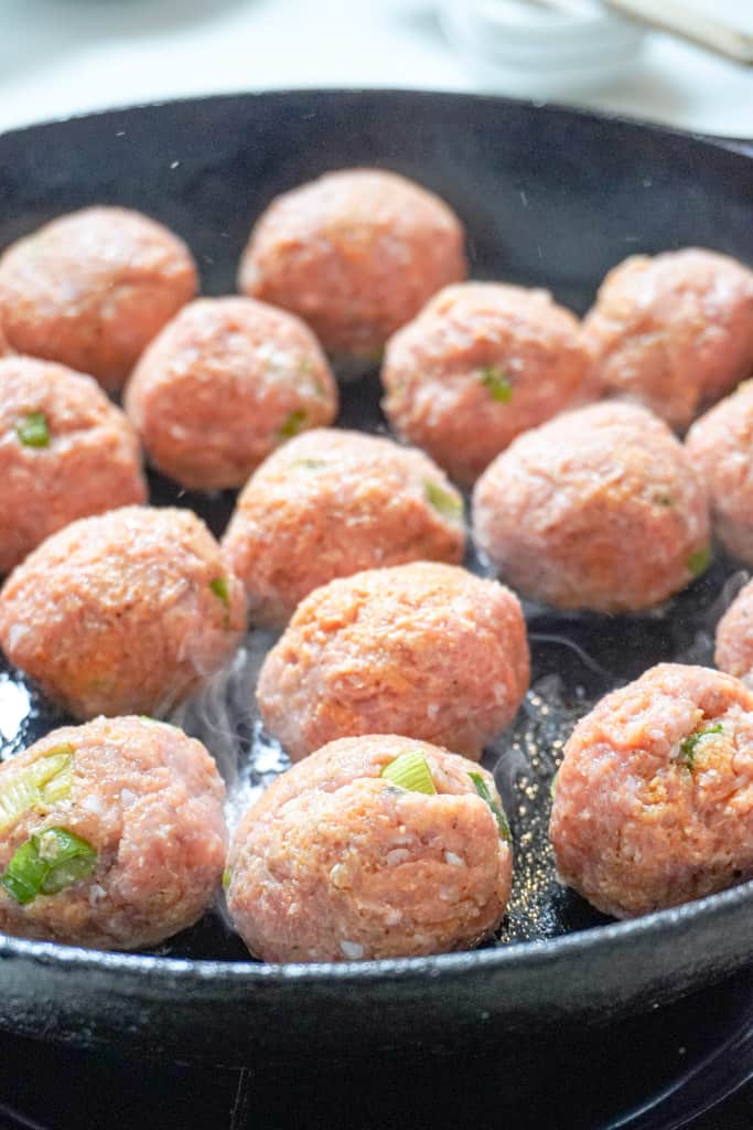 meatballs cooking in a skillet