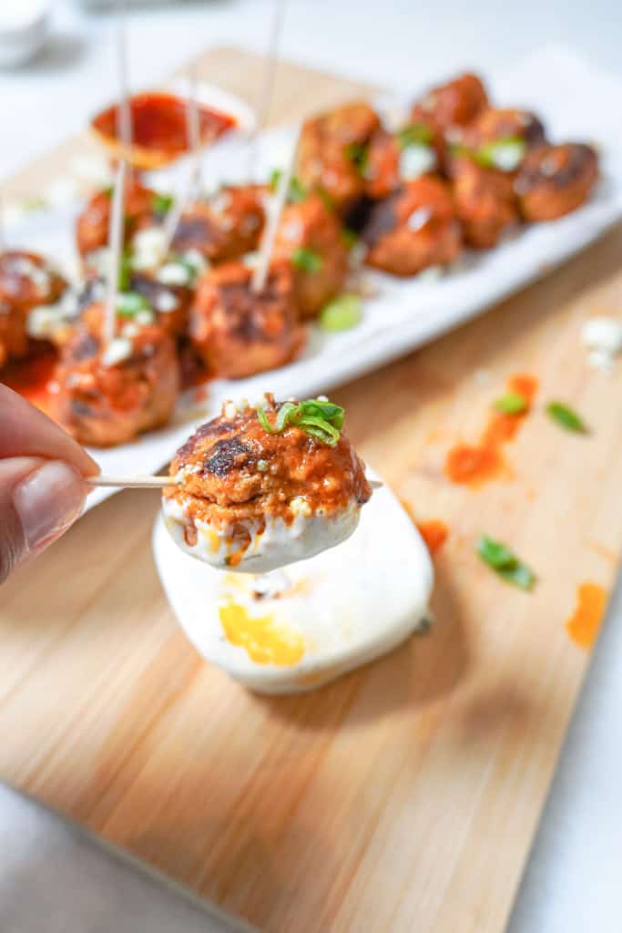 dipping a buffalo chicken meatball in ranch dressing