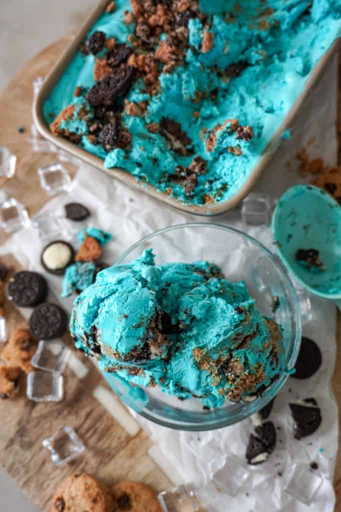 ice cream in a clear bowl with small pieces of cookies around it