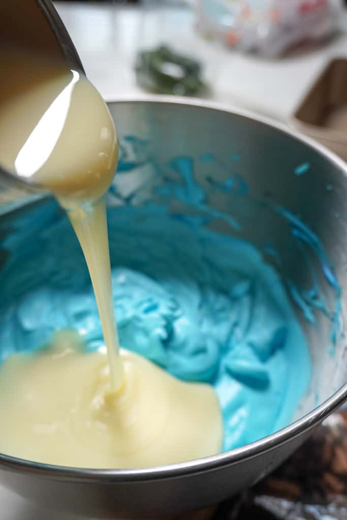 pouring condensed milk into cookie monster ice cream