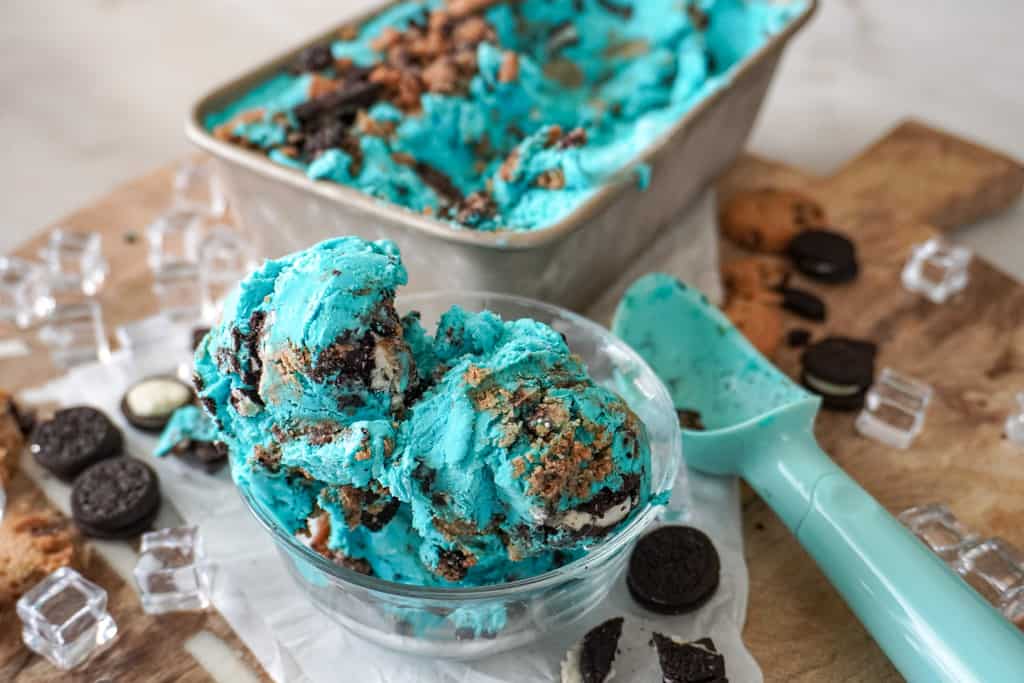 cream in a clear bowl with small pieces of cookies around it