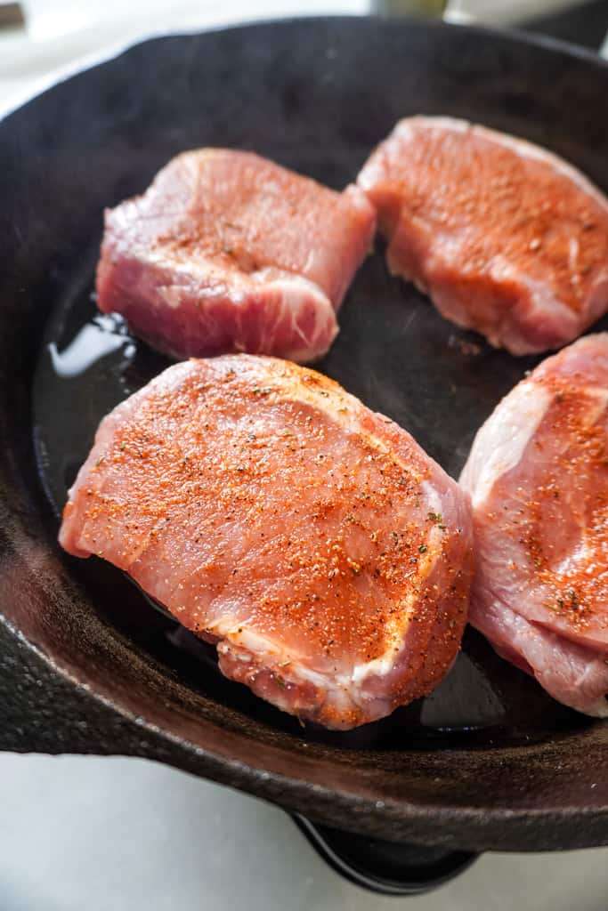searing pork chops in a skillet