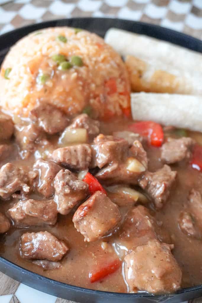 carne guisada plated mexican beef stew with rice and tortillas