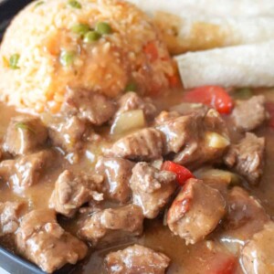 plated beef stew with tortillas and rice