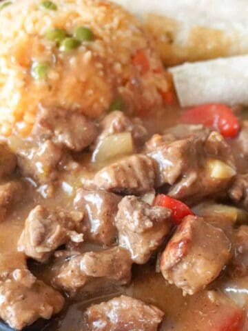 plated beef stew with tortillas and rice