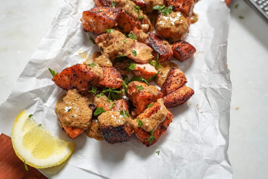 plated salmon bites with cajun garlic butter and a wedge of lemon