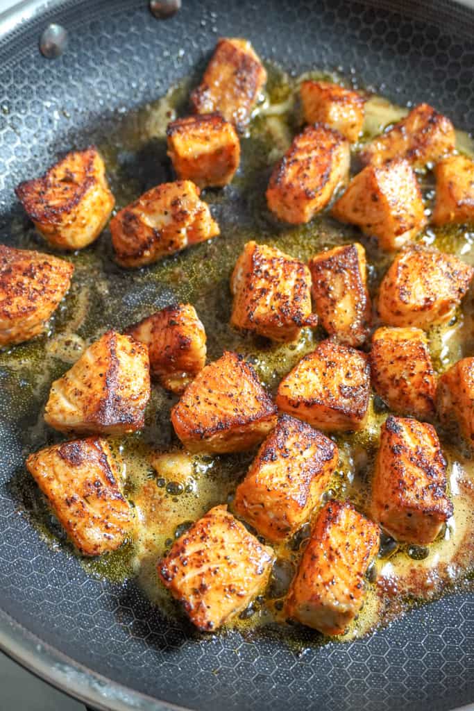 salmon bites frying in a skillet