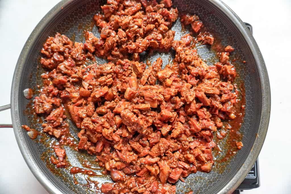 brisket tossed in a sauce in a skillet