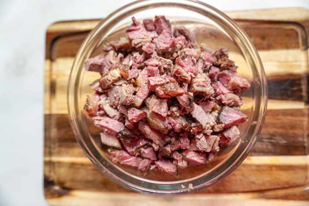 overhead view of a clear bowl filled with chopped brisket