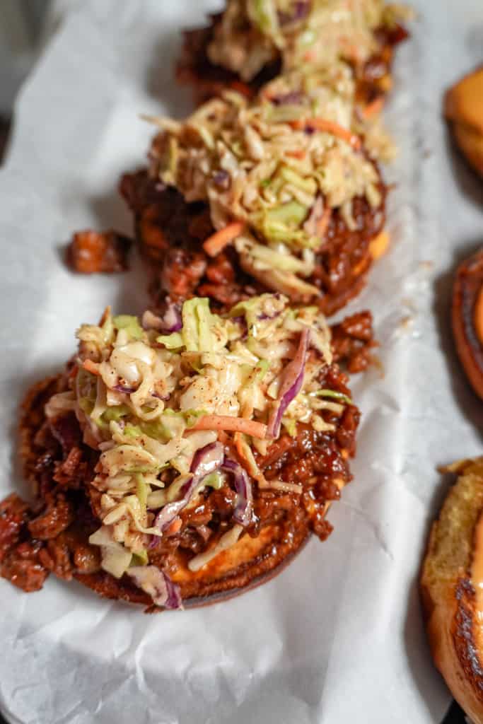 open face brisket sandwiches lined up on parchment paper