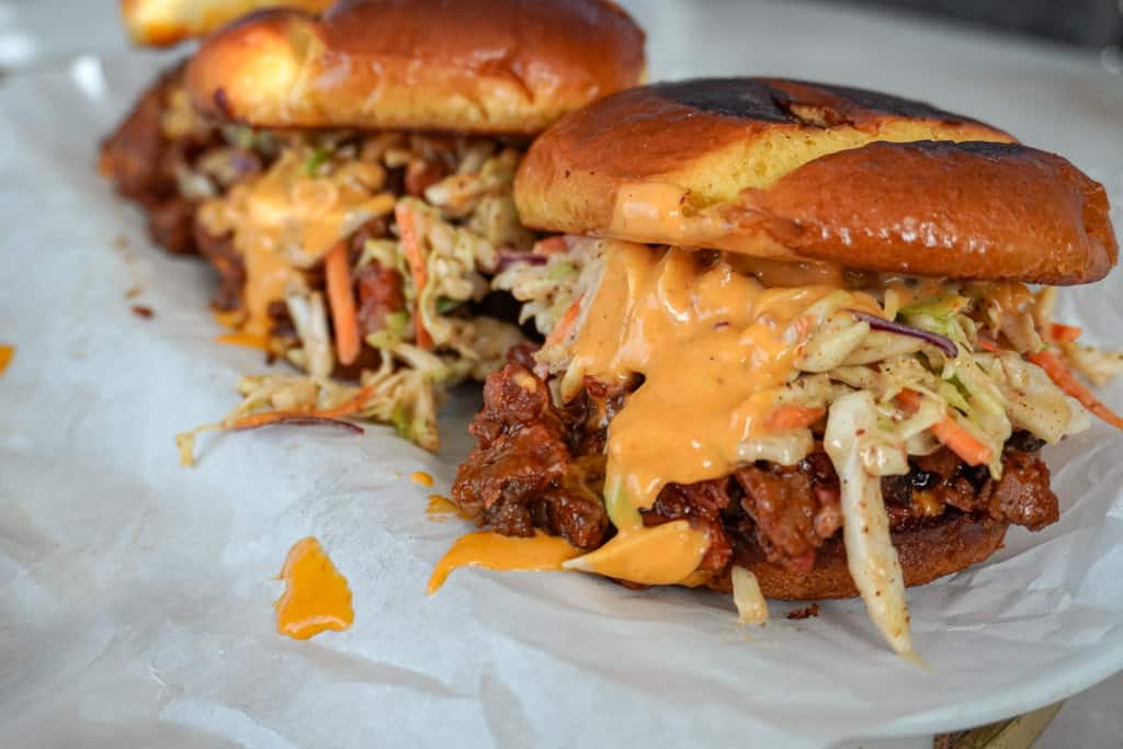 brisket sandwiches lined ip on parchment paper