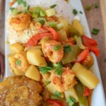 a plate of curry shrimp with rice and tostones