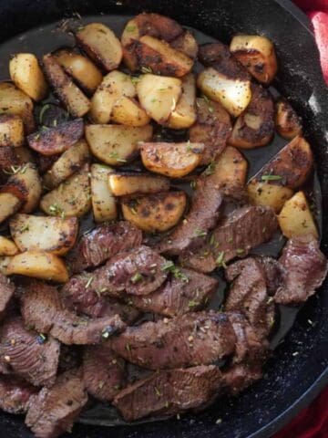 steak and potatoes in a skillet