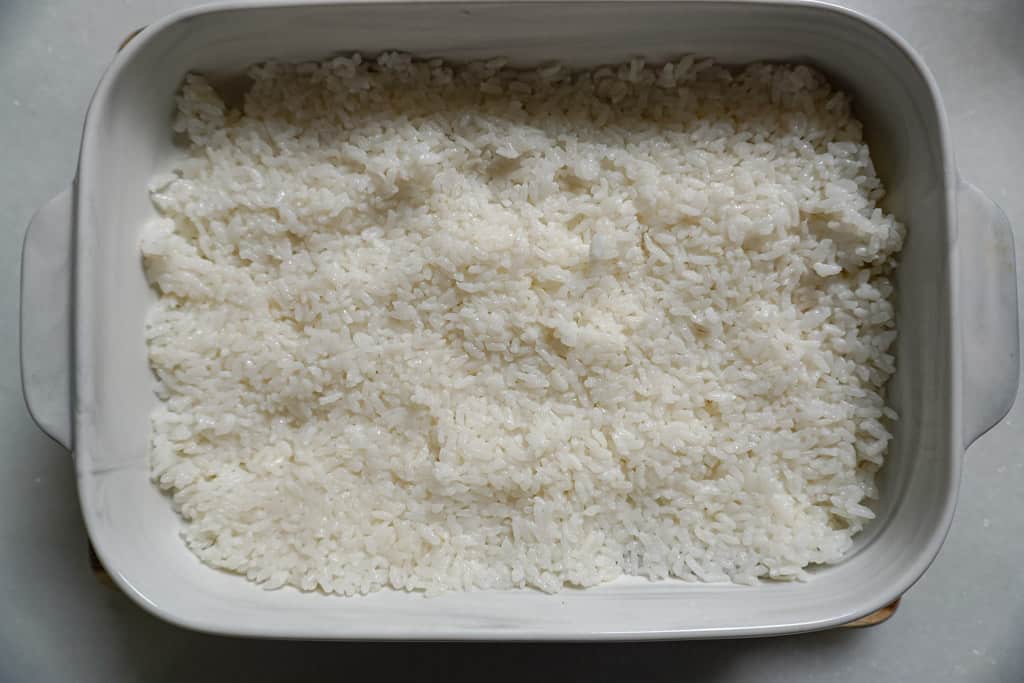 a layer of white rice in a casserole dish