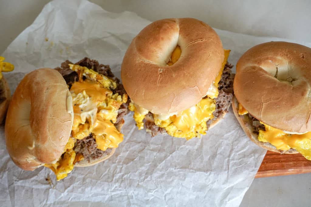 three steak egg and cheese sandwiches on parchment paper