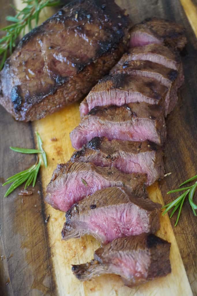 sliced medium rare steak on a cutting board