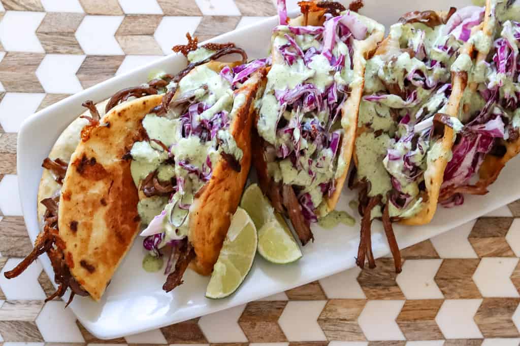 plated brisket tacos drizzled with chuy's jalapeno ranch