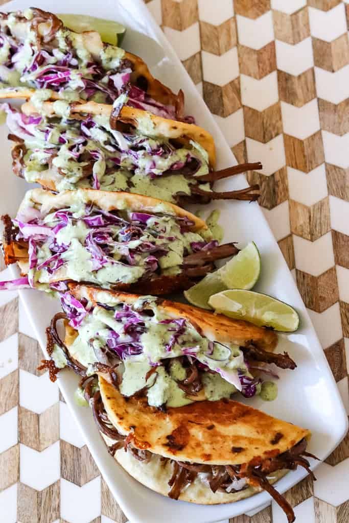 plated brisket tacos drizzled with jalapeno ranch