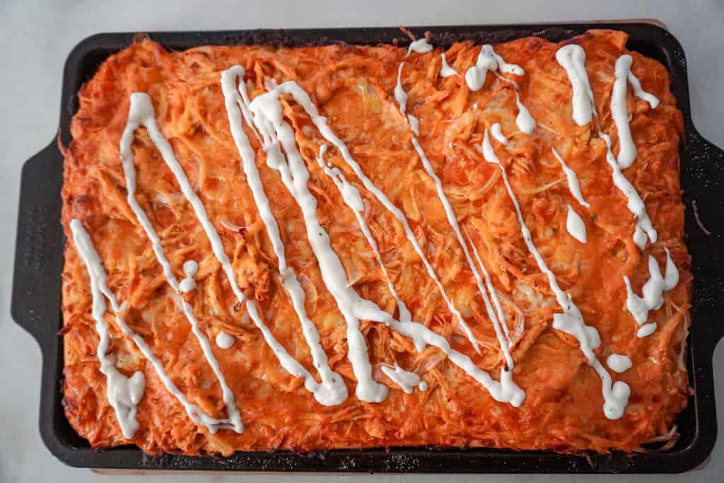 baked sheet pan pizza drizzled with ranch dressing
