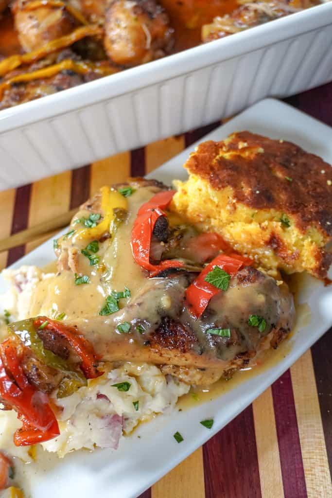 plated smothered chicken with veggies, mashed potatoes, and cornbread