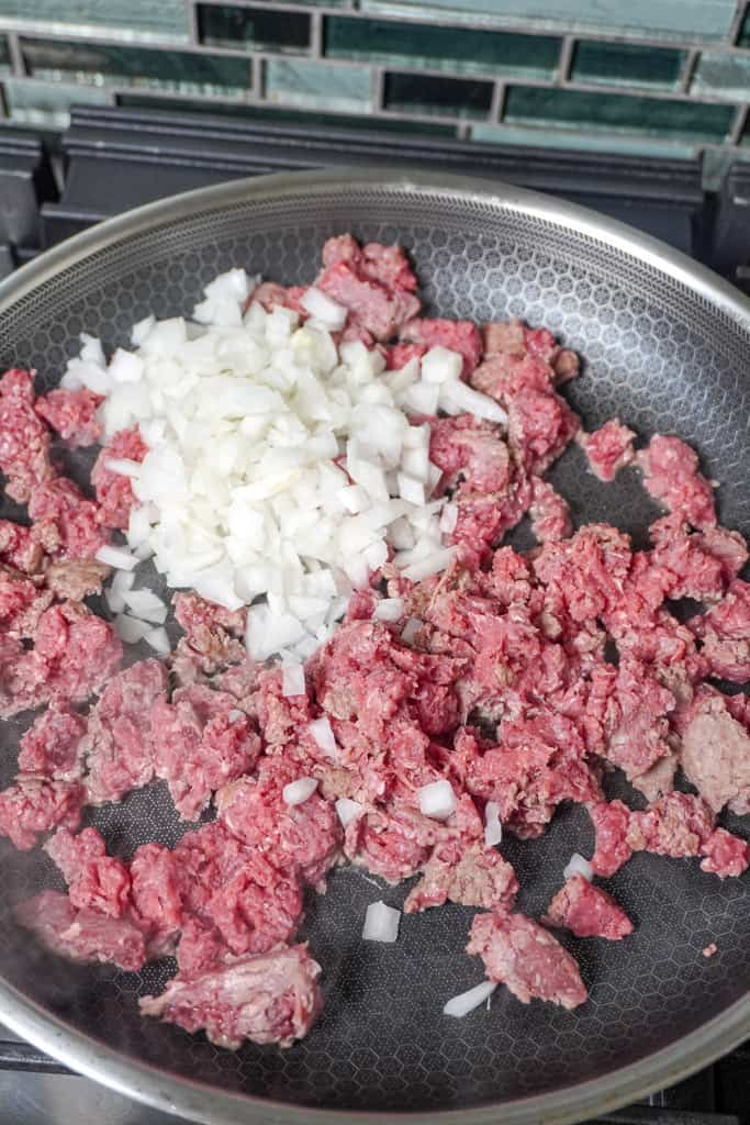 raw ground beef cooking in skillet