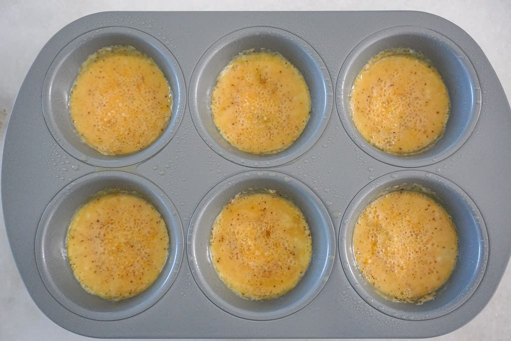 uncooked scrambled eggs in a muffin pan