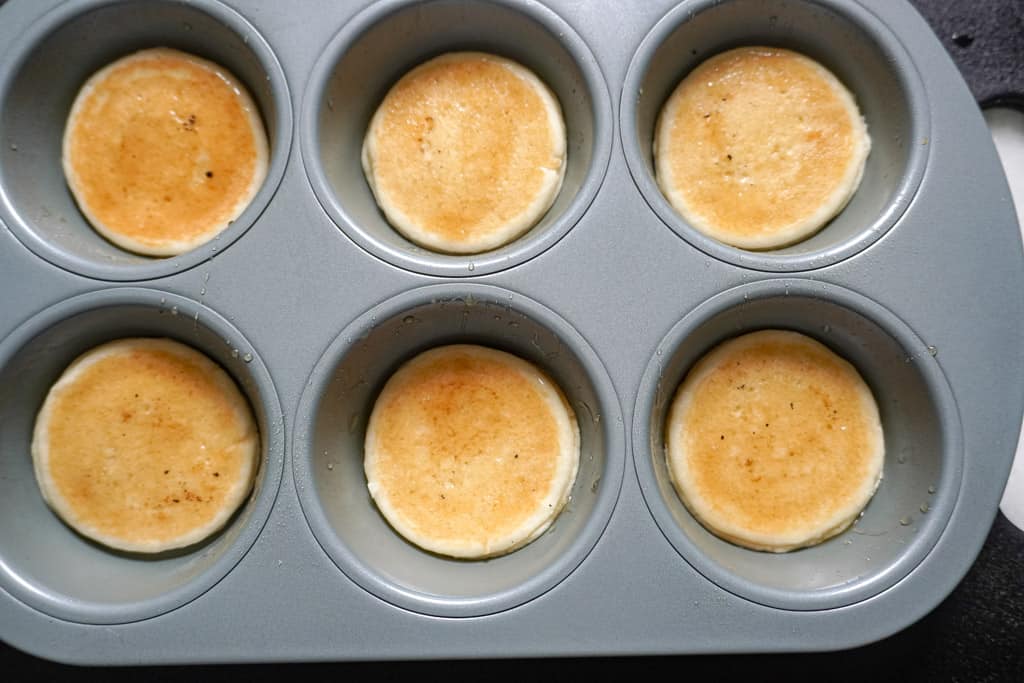 mini pancakes placed at the bottom of muffin tins
