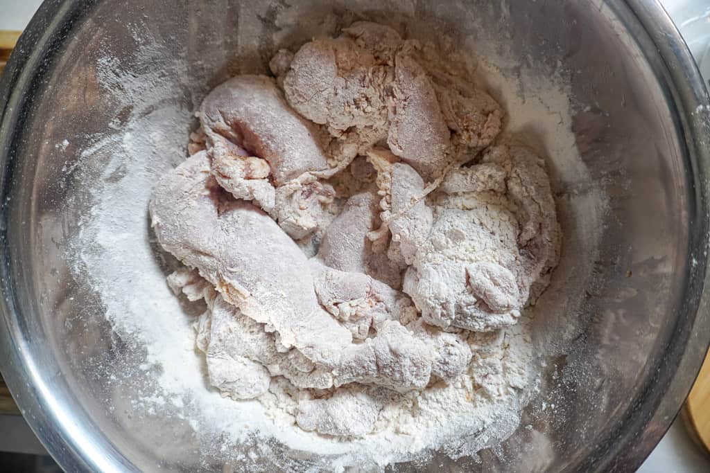 chicken dredged in flour in a bowl