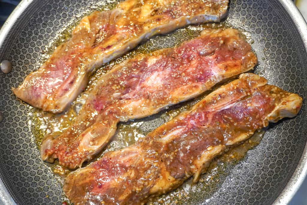 steak frying in skillet