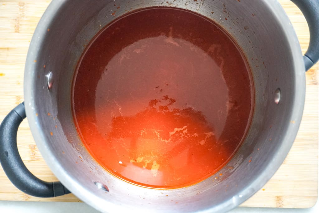 overhead view of a pot containing birria consome sauce