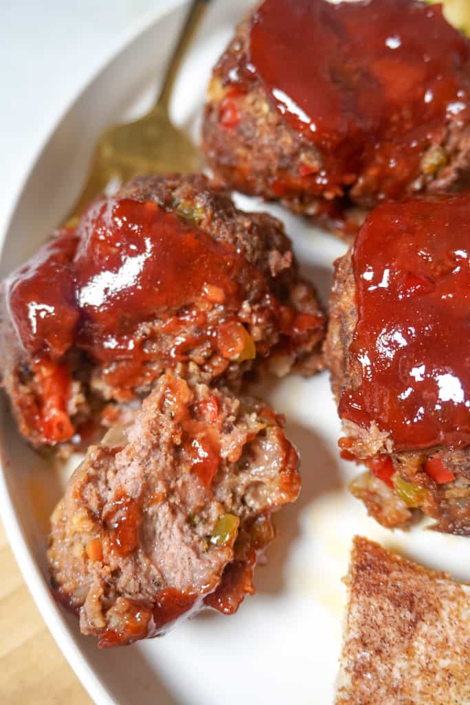 Mini meatloaf recipe close up view of plated mini meatloaf with one sliced in half to reveal the center